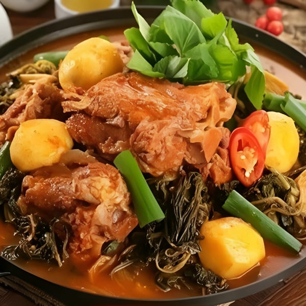 A close-up of Macheko's Korean gamjatang, a hearty pork bone soup with potatoes, greens, and chili.